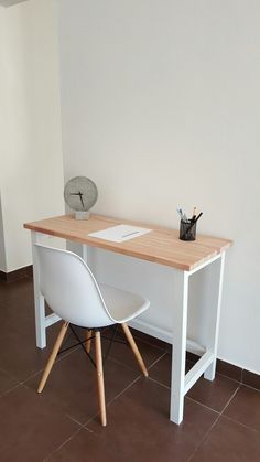 a desk with two chairs and a clock on it