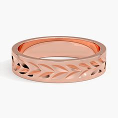 a rose gold wedding ring with leaves on the side and an engraving pattern in the middle