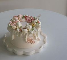 a cake decorated with flowers on top of a white table