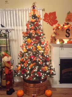 a decorated christmas tree in the corner of a living room with pumpkins on the floor