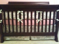 a baby crib with pink and white bedding