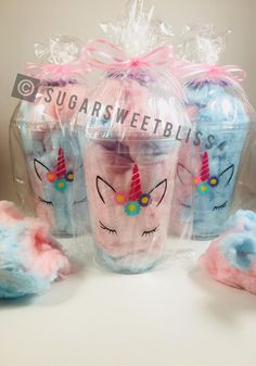 three plastic cups with unicorns on them and some cotton balls in the bag next to them