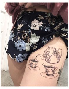 a woman's thigh with tattoos on her legs and teacups drawn on it