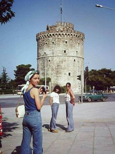 three women standing in front of a tall tower