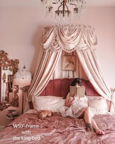 a woman is sitting on her bed in front of a chandelier and mirror