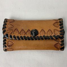 an old leather wallet with black stitching on it