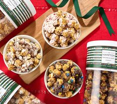 three bowls filled with popcorn next to two bags of candy canes on a cutting board