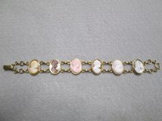 "Such an exquisite cameo bracelet! This one is rather rare, 6 beautiful genuine hand carved cameos are the focal point of this stunning piece. It is vintage 50's/60's Van Dell, new old stock, in excellent vintage condition. Well made in 12kt. gold filled to last for many years to come! It is 7 1/4\" long and 3/4\" wide. A double locking alligator clasp for security. Six different genuine shell cameos interlocking with polished gold, just gorgeous. Of course it is hallmarked Van Dell, and 12kgf." Vintage Brass Jubilee Bracelet, Victorian Cameo Bracelet, Vintage Oval Gold Bracelet For Formal Occasions, Vintage Adjustable Cameo Bracelet, Vintage Brass Gold Bracelet With Jubilee Design, Adjustable Vintage Cameo Bracelet, Vintage Oval Gold Bracelet For Gifts, Vintage Oval Gold Bracelet As Gift, Vintage Oval Gold Bracelet Gift