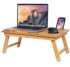 an open laptop computer sitting on top of a wooden desk next to a mouse and keyboard