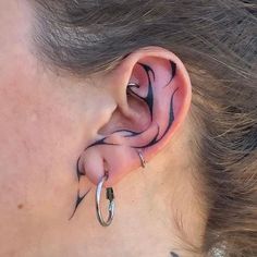 a woman's ear with black and white swirl designs on the inside of it