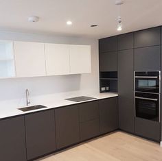 an empty kitchen with black and white cabinets