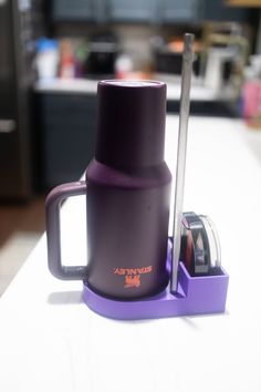 a purple coffee cup sitting on top of a counter