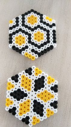 two black, white and yellow beaded coasters sitting on top of a table