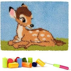 a baby deer is laying down on the ground next to some crayons and markers