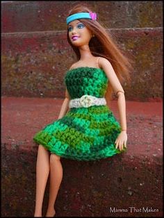 the doll is wearing a green dress and headband