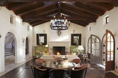 a large living room with an open fireplace and chandelier hanging from the ceiling