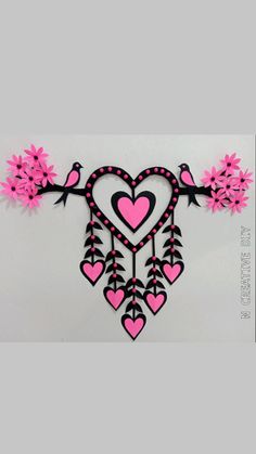 pink and black paper cutout with hearts hanging from the side, on a white background