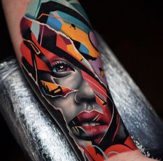 a man's arm with colorful tattoos on it and his face painted in different colors