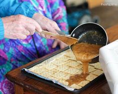 an older woman is making crackers on a tray with a wooden spoon in it