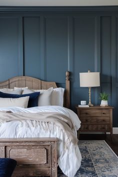 a bedroom with blue walls and white bedding