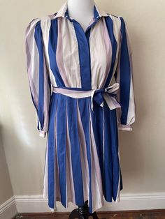 "Vintage blue, white, and gray striped dress by Top Act. Marked size 14, shoulder pads, pleated full skirt with matching belt. Top has lining, shoulder pads. Best for size L/XL.  Please ask questions!  Measurements (laid flat):  Tag Size: 14 Length: 40\" Pit to Pit: 21\"x2 Waist: 19\"x2 Hips: 29\"x2 Condition: Great vintage condition, no issues noted.  The vintage pieces I sell have all led a previous life and may tell their stories through minor imperfections. I'll do my best to indicate overall condition, but please refer to the pictures. Your purchase continues the life of this garment...what stories will you tell while wearing it?  Please note there may be a slight difference in color when comparing the actual garment to the monitor image. (0411)" Elegant Striped Belted Dress, Pleated Striped Dresses For Spring, Summer Striped Pleated Dress, Blue White Striped Dress, Christmas Vest, Vintage Blue And White, Belt Top, Blue And White Dress, Previous Life