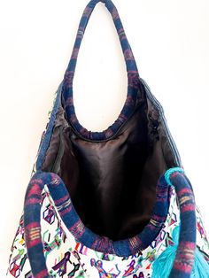 Designed to have everything you wanted in a carry-all tote for your towels, cell-phone, water bottle, this up-cycled tote is designed to be spacious and stylish. Handwoven by skilled artisans in Guatemala, features a geometric pattern and a contrast tassel. Fabric: Huipil from Guatemala One of a kind fabric tassel accents Open top Interior pocket Shoulder straps Black lining for water protection Weight: 12oz / 0.34kg 17 x 17'' approx. Handwoven by women artisans in Guatemala using traditional te Multicolor Rectangular Bag With Water Bottle Pocket, Everyday Tote Bag With Water Bottle Pocket, Bohemian Upcycled Bags For Everyday Use, Bohemian Shoulder Bag With Cell Phone Pocket For Travel, Artisan Tote Beach Bag For Travel, Artisan Beach Bag Tote For Travel, Artisan Beach Tote Bag For Travel, Artisan Multicolor Beach Bag For Travel, Artisan Hobo Tote Bag For Travel