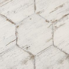 an old white hexagonal tile pattern with some brown spots on it's edges