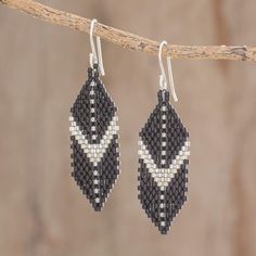 Promoting the artisanal skills of young village women in El Salvador Pearls of the Sea Youth Group presents this striking pair of dangle earrings. Crafted by hand from petite glass beads these geometric earrings showcase hues of black and silver. These earrings swing from hooks of sterling silver. Artisan Handwoven Silver Jewelry, Handwoven Dangle Jewelry, Silver Handwoven Dangle Jewelry, Black Handwoven Dangle Jewelry, Handwoven Black Drop Earrings, Black Handwoven Drop Earrings, Seed Bead Jewelry Tutorials, Ad Earrings, Village Women