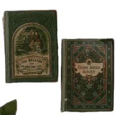 two old books are sitting next to each other on a white surface, one is green and the other is red