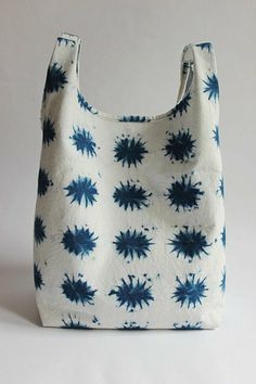 a blue and white bag sitting on top of a white table next to a wall