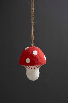 a red and white mushroom ornament hanging from a rope