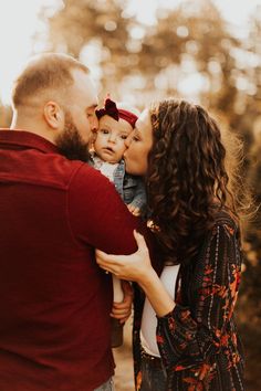 a man and woman kissing their baby boy