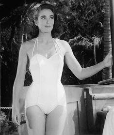 a woman in a bathing suit standing next to a pool