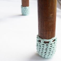 two crocheted wooden poles on a white surface