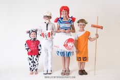 three children in costumes holding signs and standing next to each other on a white background