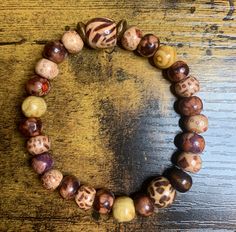 This one-of-a-kind bracelet features a brown and cream accent bead with brown wood spacer beads and small multi-colored round wood beads.  The beads are held securely in place with extra-strong stretchable, crystal cord that is doubled for additional durability. This is a perfect bracelet for every day wear. This bracelet measures seven inches. Depending on your preference of style, this bracelet is appropriate for a six to eight inch wrist. I make one-of-a-kind bracelets, so I am not able to of Luxury Brown Round Bead Bracelets, Wood Bead Jewelry, Bead Jewelry Ideas, Round Rock, Bead Jewelry, Brown Wood, Spacer Beads, Wood Beads, Multi Colored