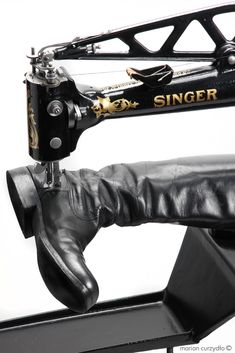 a close up of a sewing machine with leather boots on it's feet and foot