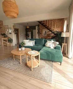 a living room filled with furniture next to a wooden table and stairs in the background