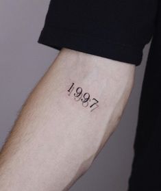 a person with a tattoo on their arm that reads,'1897'in cursive font