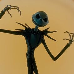 a cartoon character with arms outstretched in front of an orange background, wearing a black and white striped suit