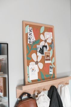 a purse is sitting on a shelf next to a wall with pictures and magnets