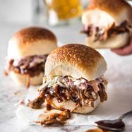 two pulled pork sliders with cole slaw on the side