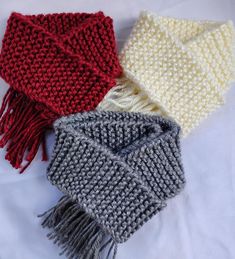 three knitted scarves laying on top of each other