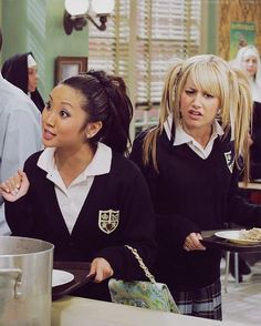 two girls in school uniforms are serving food