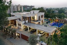 an aerial view of a house with cars parked in the driveway and trees surrounding it