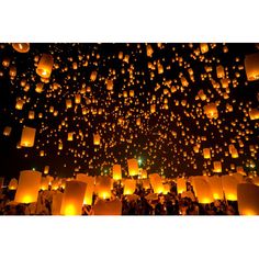 many lanterns are floating in the air at night