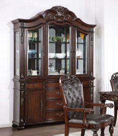 an ornate china cabinet with glass doors and leather upholstered chairs in a living room