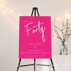 a pink sign with the words forty written on it in front of a white table