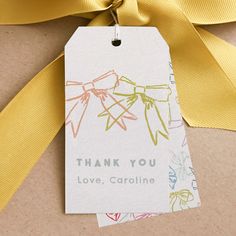 a thank you tag attached to a yellow ribbon on top of a brown package with the words love, carolina