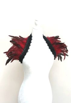 a white mannequin with red and black feathers on it